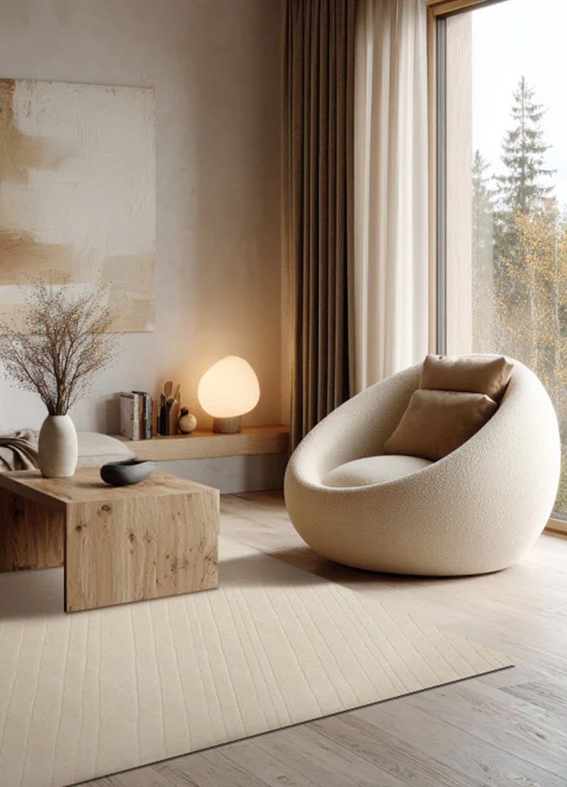 Natūralios vilnos rankų darbo kilimas Japandi styliaus interjere šalia boucle fotelio ir medinio kavos staliuko. Makeyourcasa.lt | Carpetdecor