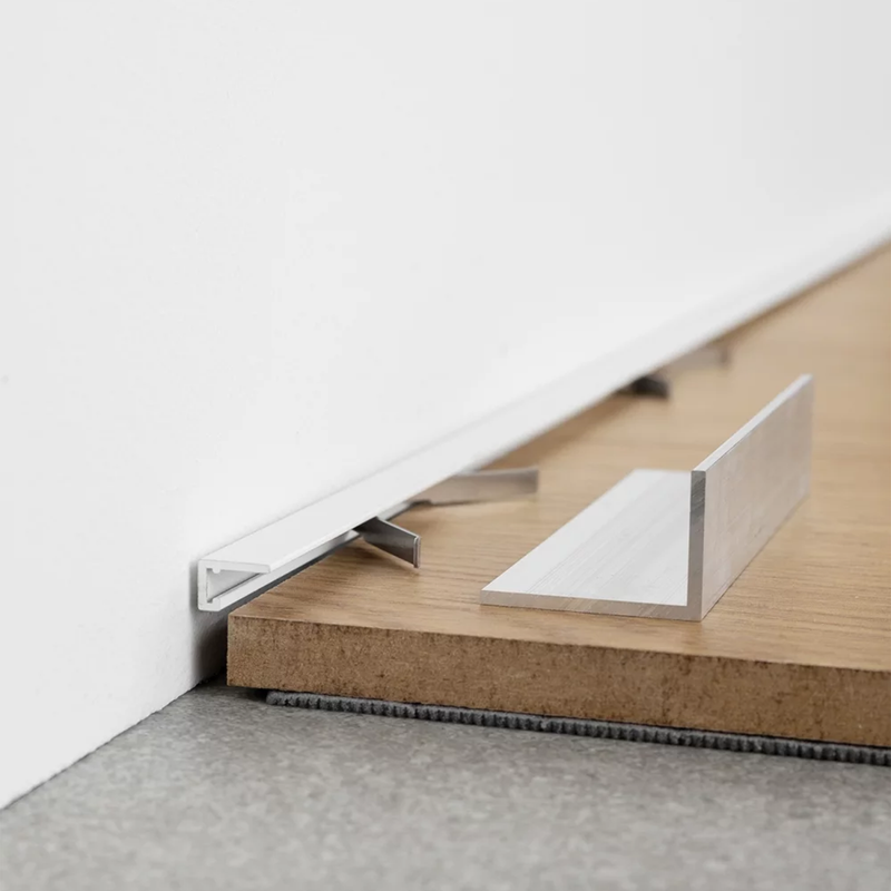Minimalistinis baltos spalvos plintusas Minileiste, kuris puikiai tinka prie parketo, laminto, vinilo dangos