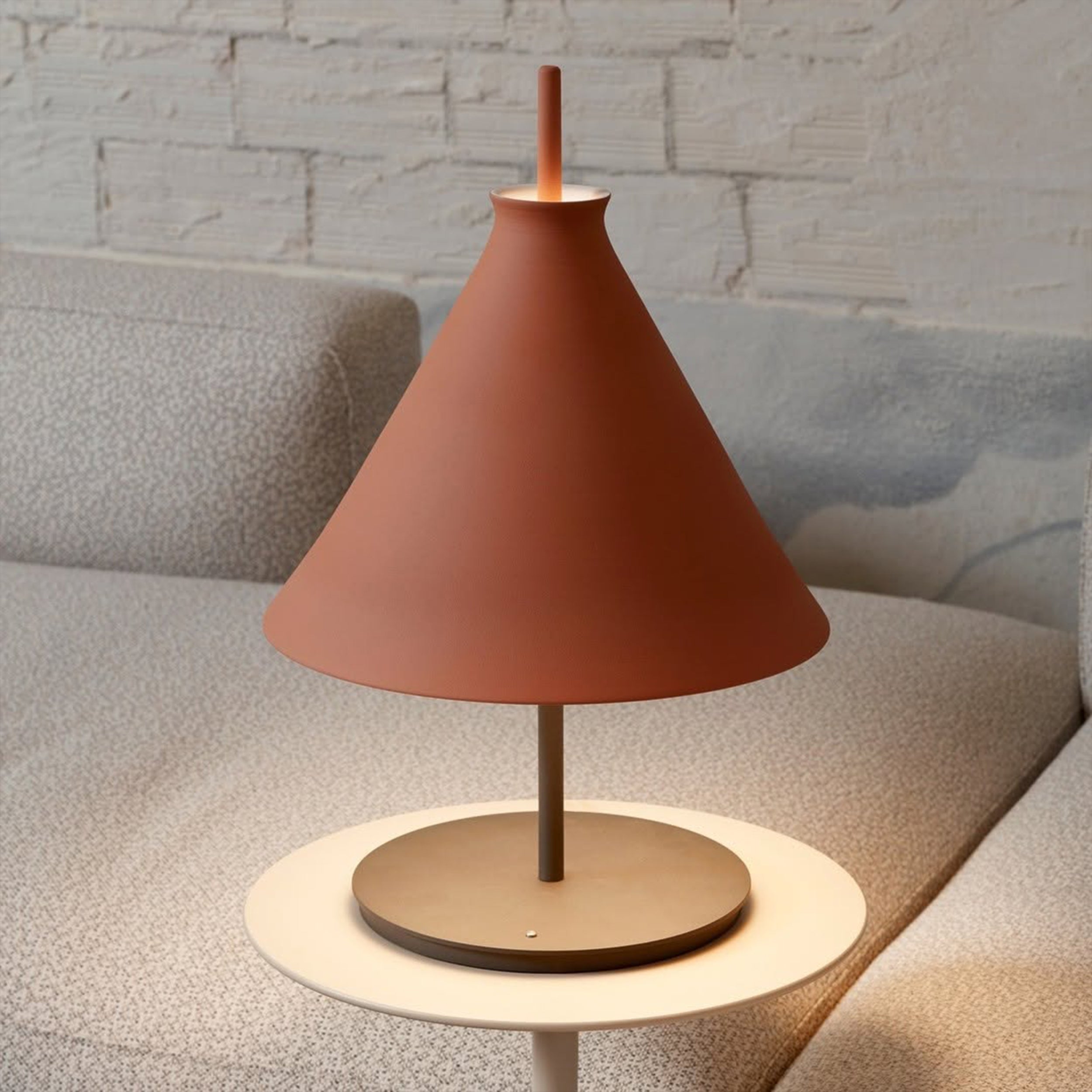 Pott Totana pastatomas šviestuvas iš natūralaus molio šalia kreminės spalvos boucle audinio sofos