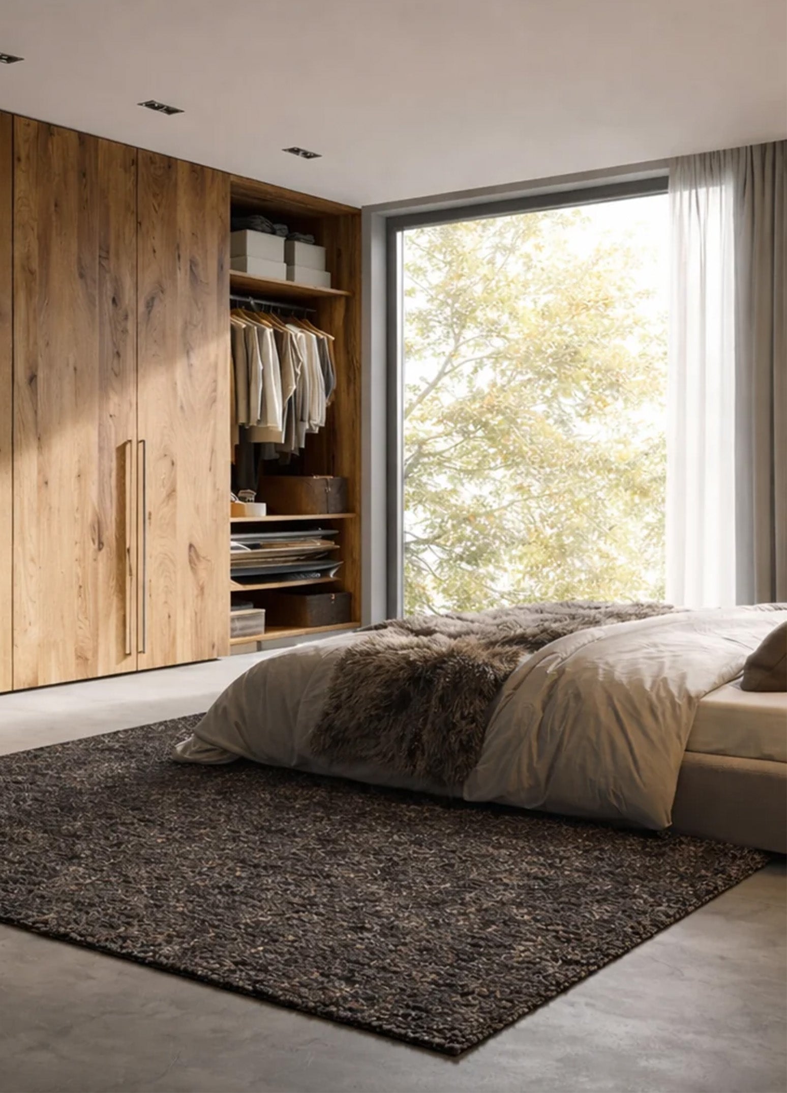 Mellow Brown kilimas minimalistiniame miegamojo interjere prie modernios ir stilingos žemos lovos ant pilkos spalvos mikrocemento grindų.