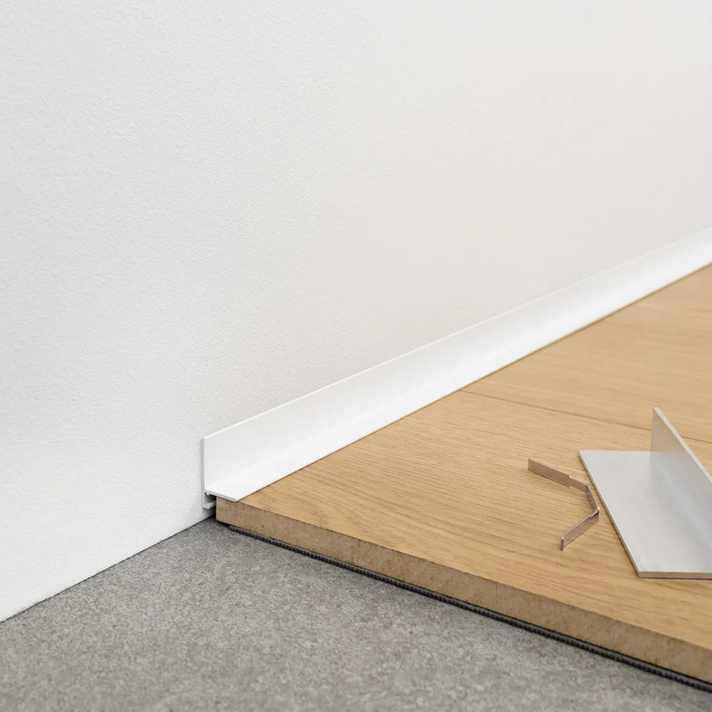 Minimalistinė grindjuostė Minileiste su laikikliais ir montavimo įrankiu prie sienos | makeyourcasa.lt