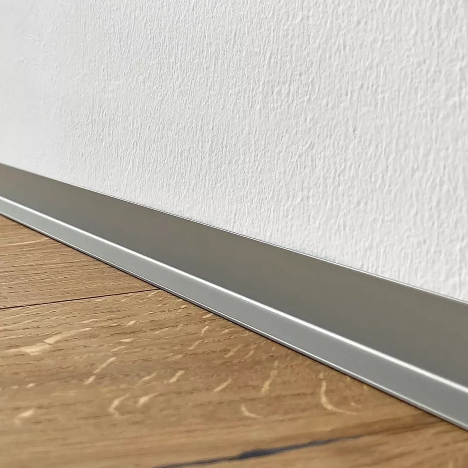 Minileiste grindjuoste Sl16x5 titano spalvos interjere šalia medžio grindų ir baltos tekstūruotos sienos | makeyourcasa.lt