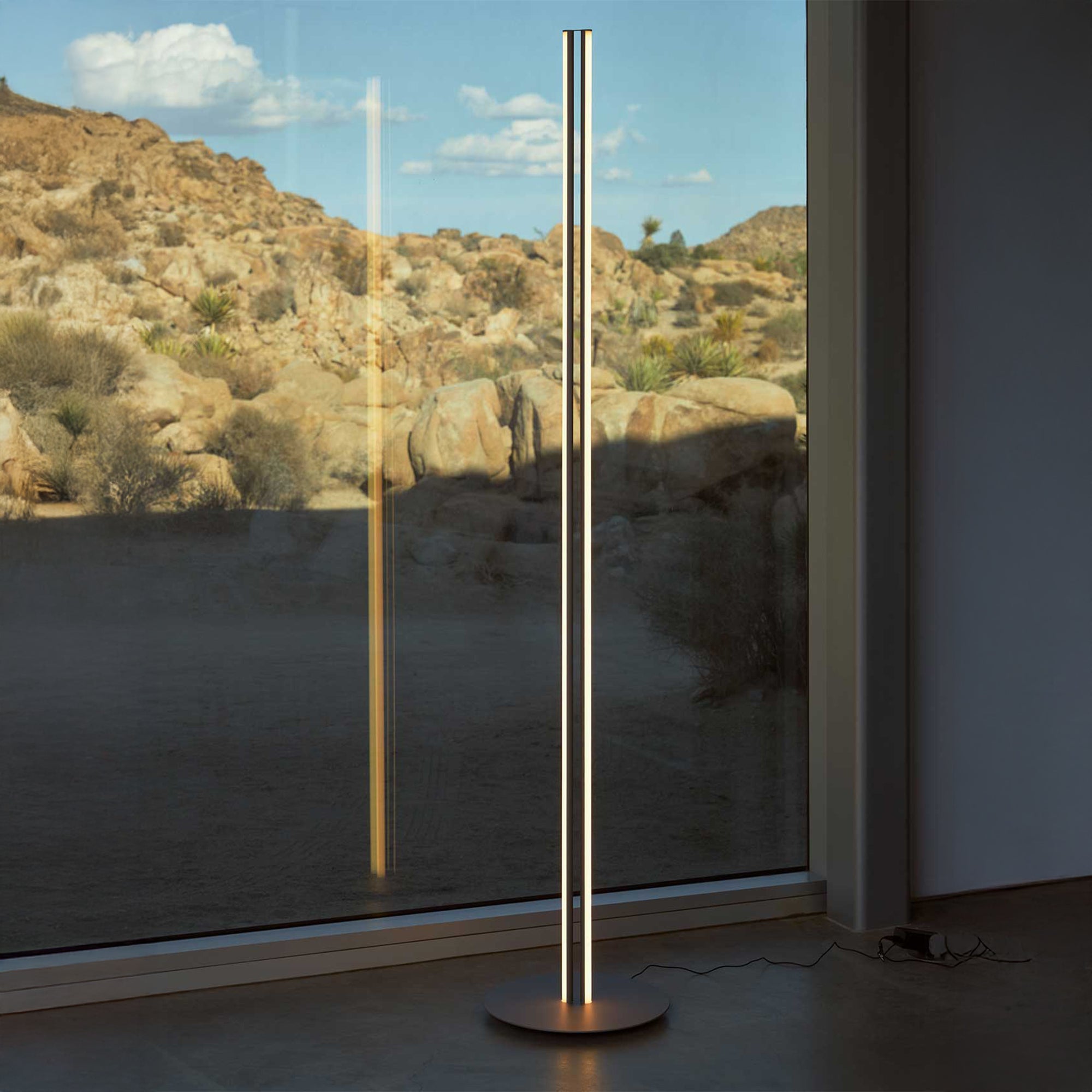 Du vertikalūs LED stiebai su apvaliu pagrindu Flos gamintojo Coordinates Floor toršeras interjere
